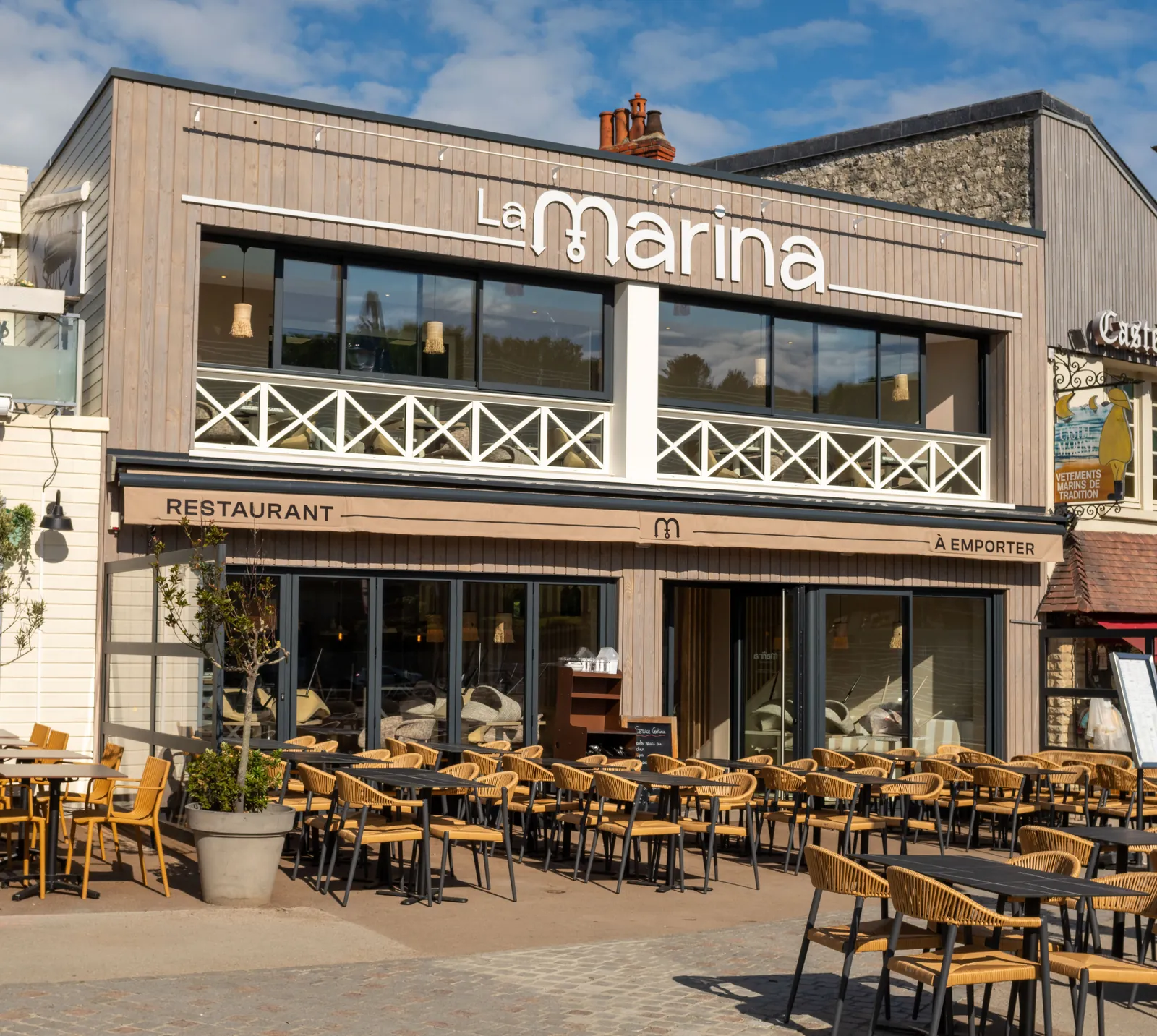 Façade du restaurant La Marina avec son enseigne, son lambrequin et sa terrasse