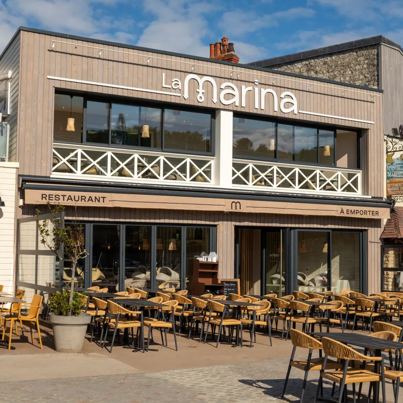Façade du restaurant La Marina avec son enseigne, son lambrequin et sa terrasse