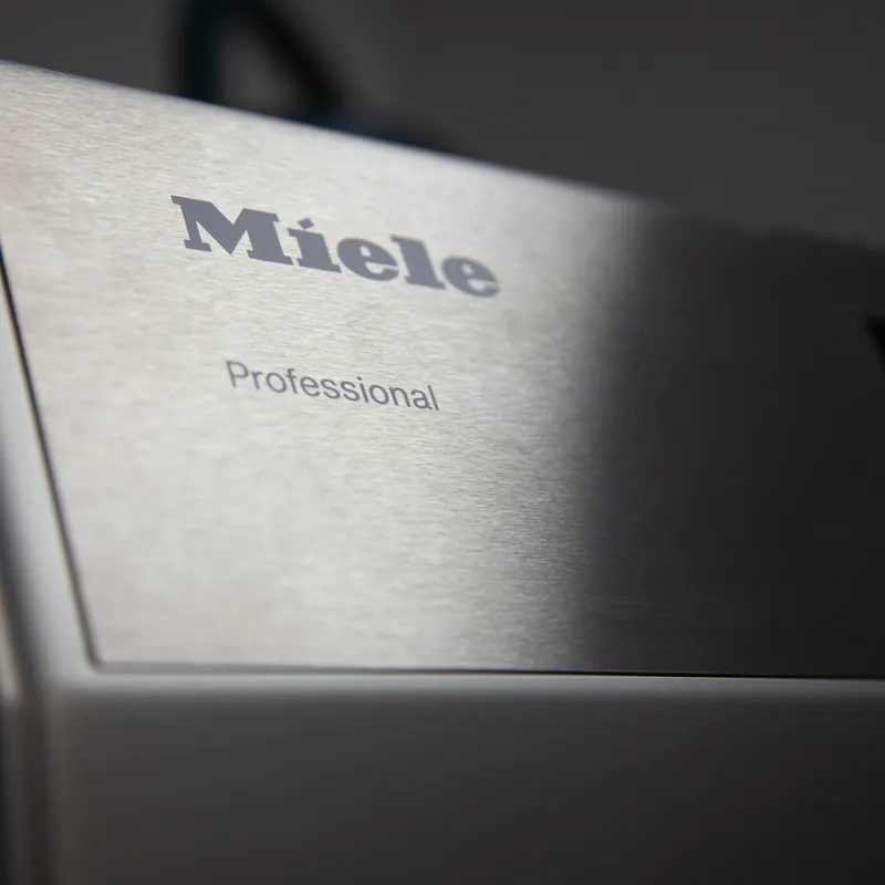 Gros plan sur le panneau en inox brossé d'une machine Miele Professional