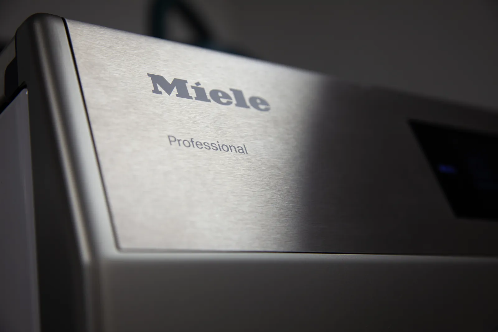 Gros plan sur le panneau en inox brossé d'une machine Miele Professional
