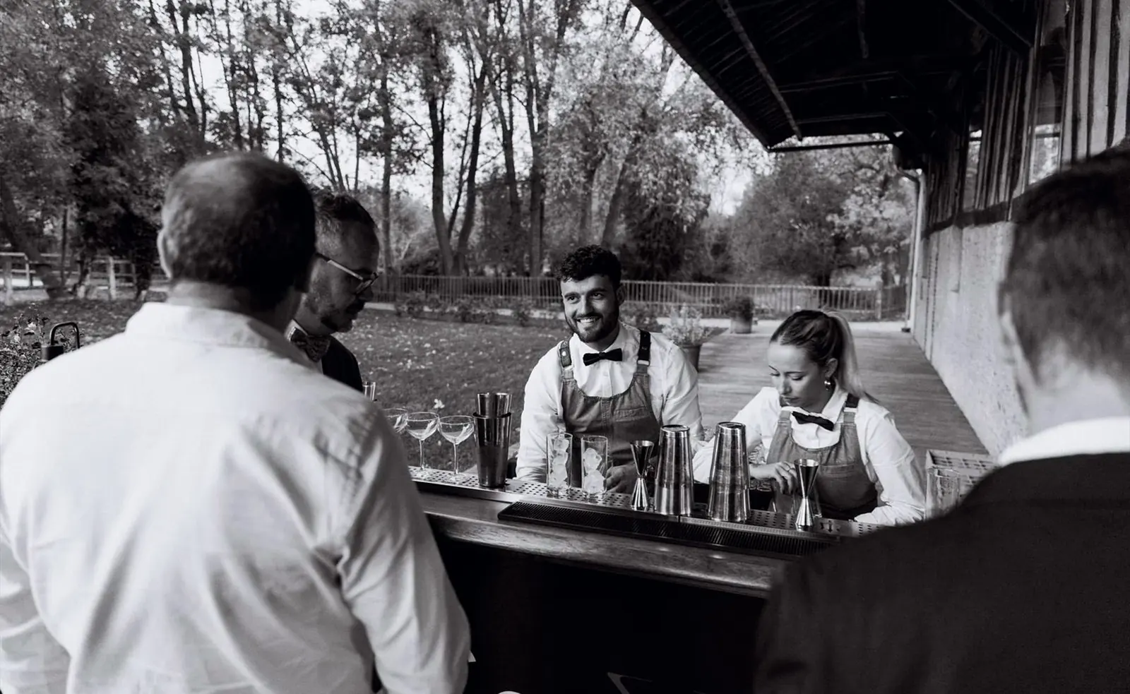 Les barmen de Sawyer Cocktail servent derrière le bar pendant un événement, photo en noir et blanc