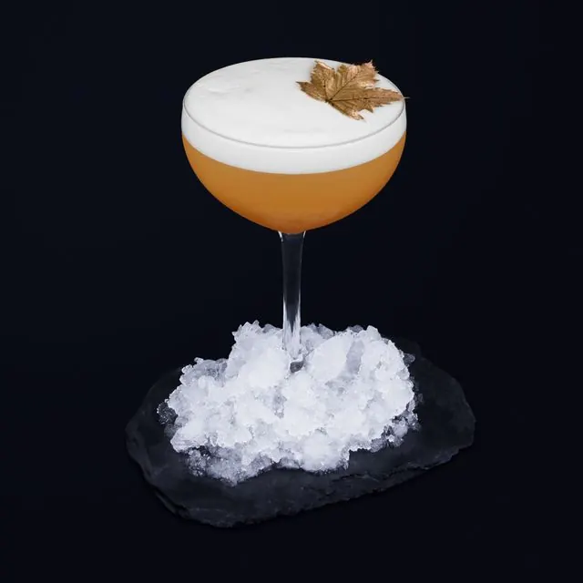 Cocktail mousseux décoré d'une feuille d'érable