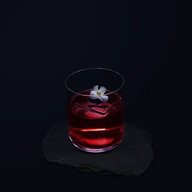 Cocktail rouge sombre à la fleur blanche