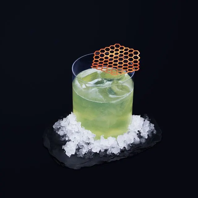 Cocktail vert sous une décoration en nid d'abeille