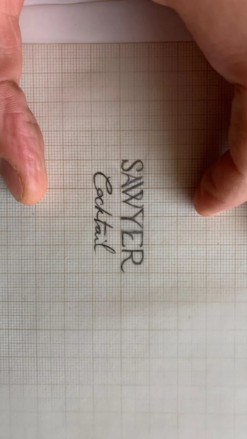Croquis à la main du mot Sawyer sur papier millimétré